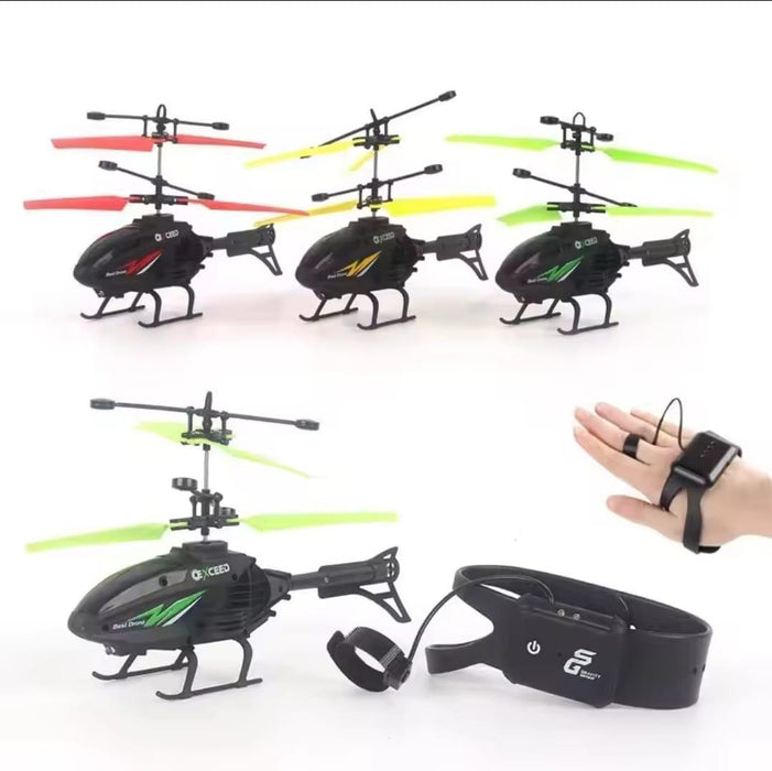 Three remote control helicopters with different colored propellers and a hand wearing a black glove with a remote control device.