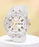 Clear wristwatch with gold accents on a light yellow background