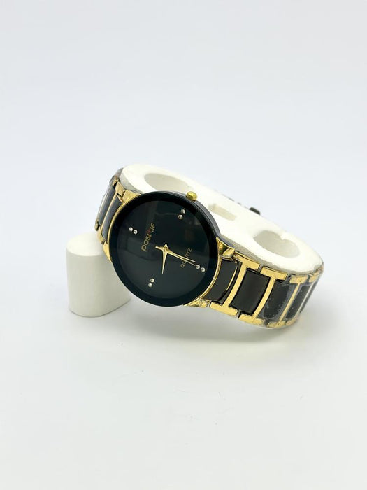 Wristwatch with gold and black design on a white background
