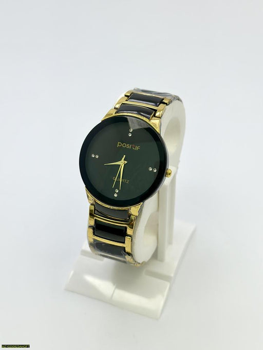 Watch with black and gold band on a white stand