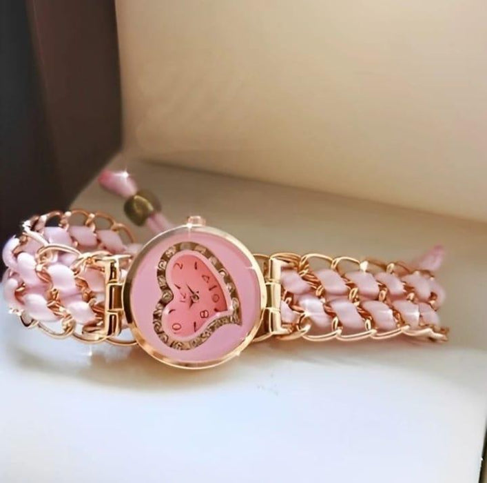 Pink and gold bracelet with heart design on a light background