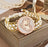 Decorative watch with white braided strap and gold accents on a wooden surface