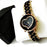 Black and gold watch with heart-shaped face on a white background