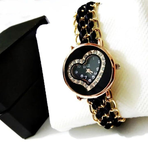 Black and gold watch with heart-shaped face on a white background