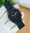 Black Emporio Armani watch on a white glove with a blurred background
