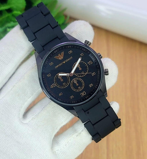 Black Emporio Armani watch on a white glove with a blurred background