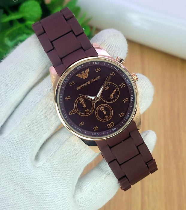 Brown Emporio Armani watch on a white glove with a blurred background