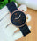 Black Emporio Armani watch on a white glove with a blurred background