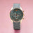 Wristwatch with a gray strap and green dial on a pink background