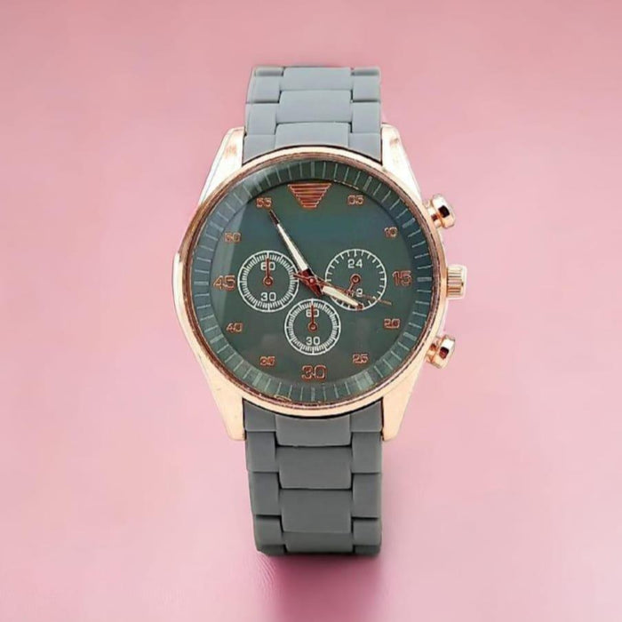Wristwatch with a gray strap and green dial on a pink background