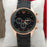 Wristwatch with black strap and rose gold case on a white cushion