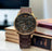 Brown Emporio Armani watch on a stack of books with a blurred background