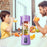 Purple portable blender with fruits inside, being used by a child and a man to drink juice.