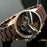 Brown wristwatch with a detailed face on a dark background