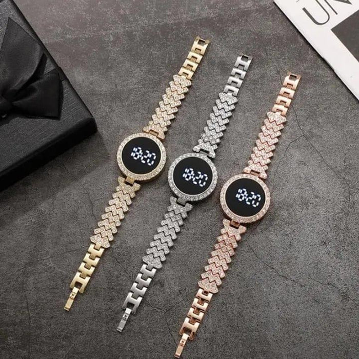 Three digital watches with gold, silver, and rose gold braided bracelets on a dark surface.