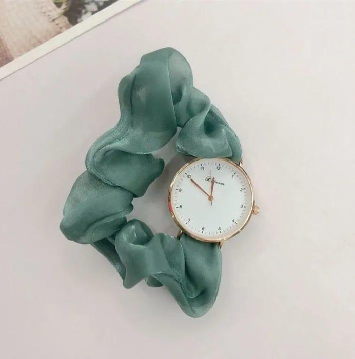 Green scrunchie with a watch face on a light background