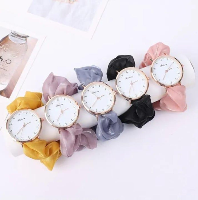 Set of wristwatches with colorful scrunchies on a white background