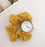Yellow scrunchie with a watch face on a white surface