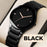 Black wristwatch with a black strap on a neutral background