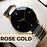 Rose gold watch with black face on a white background