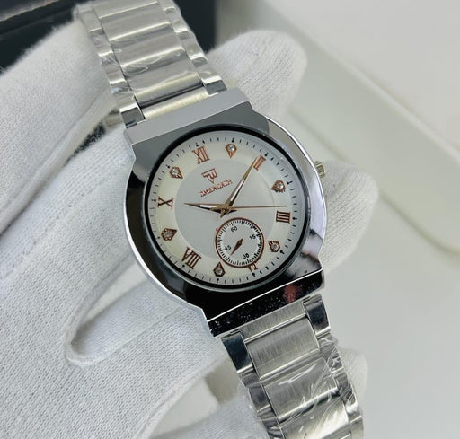Silver watch with a white face featuring Roman numerals on a white surface.