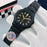 Black wristwatch with a detailed face on a white glove