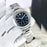 Silver watch with a black face on a white background