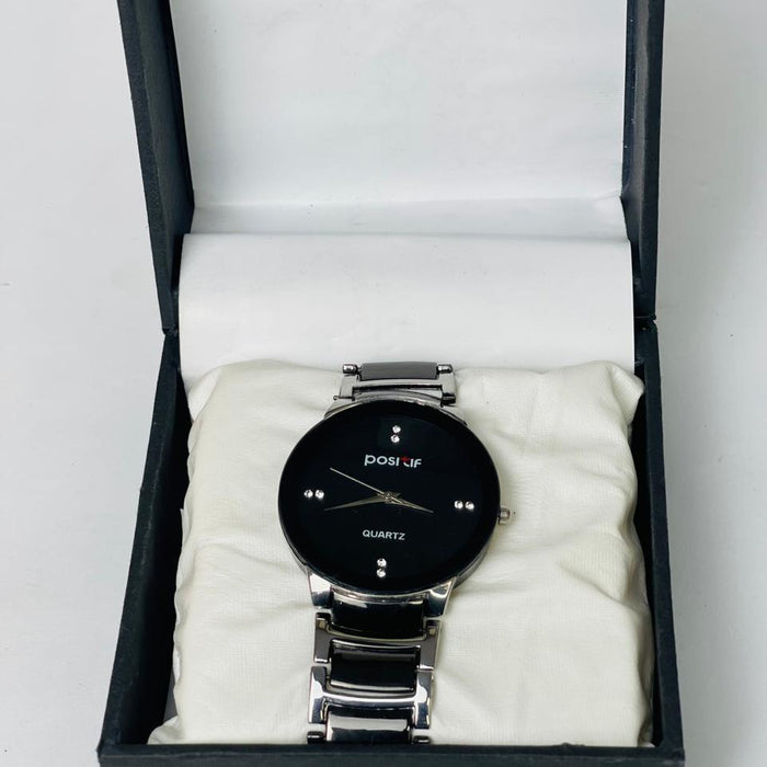 Black wristwatch with silver band in a black box on a white background