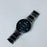Black watch with a metal strap on a white background