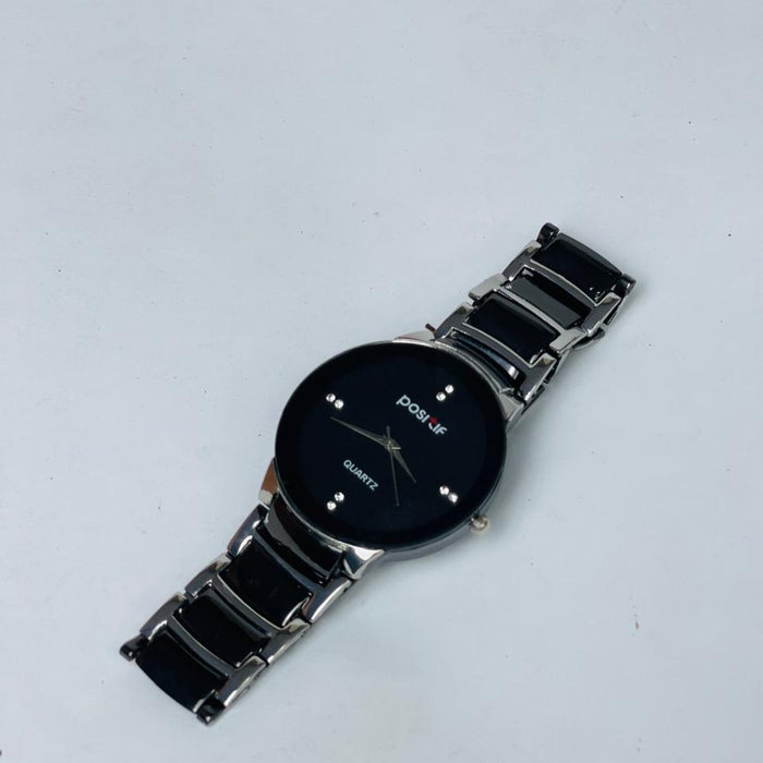Black wristwatch with a silver band on a light gray background