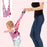 Baby walking harness with a child and a person assisting them on a light pink background.