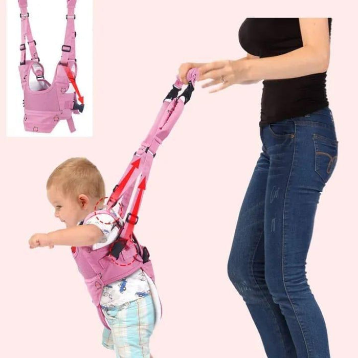 Baby walking harness with a child and a person assisting them on a light pink background.