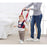 Child using a red and black walker with an adult holding it, in a home setting.