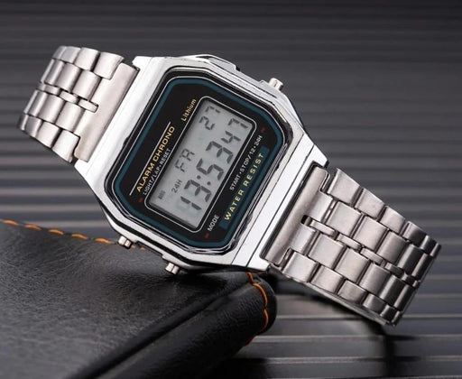 Silver digital watch with a black strap on a dark surface