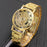 Gold wristwatch with intricate design on a dark background