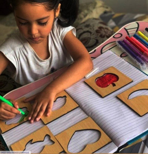 Child engaged in educational activity with shapes and markers on a table.