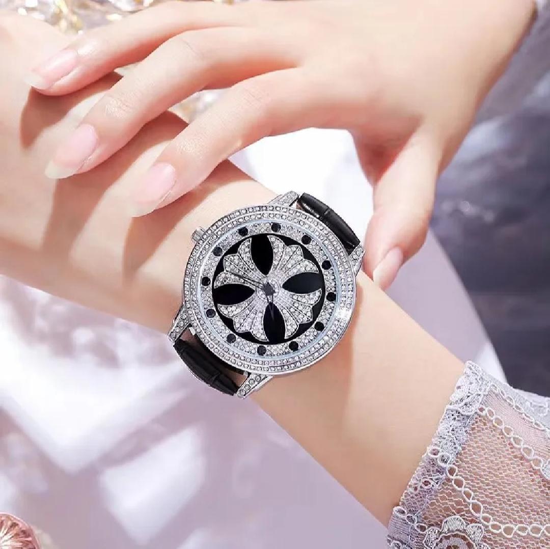 Luxury watch with black and silver design on a wrist, blurred background